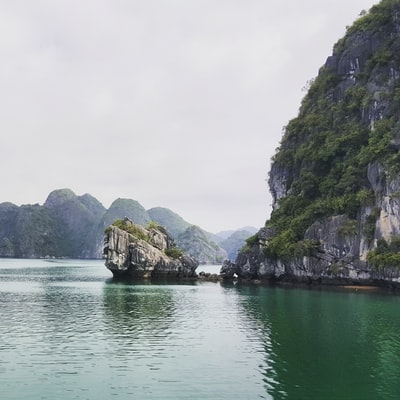 绿色和棕色山旁边的水域白天
